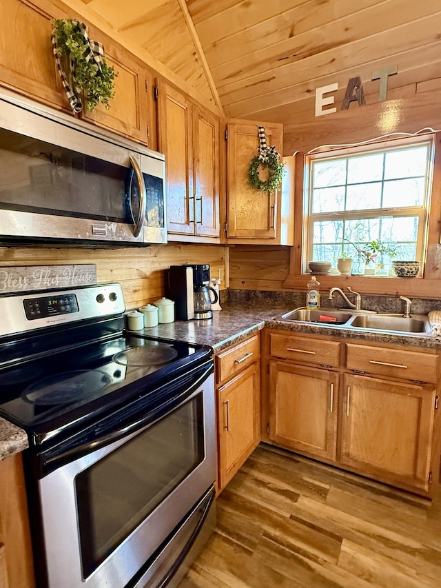 kitchen featuring appliances with stainless steel finishes, lofted ceiling, sink, light wood-type flooring, and wooden ceiling