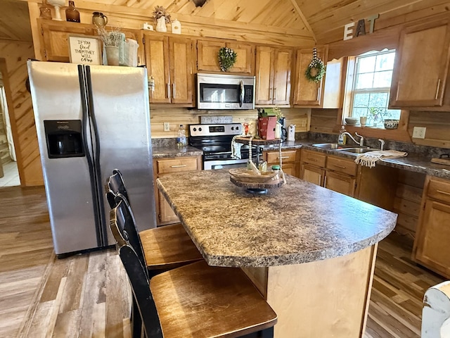 kitchen featuring light hardwood / wood-style floors, a kitchen breakfast bar, stainless steel appliances, and a center island