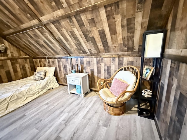 bedroom featuring wood walls, wooden ceiling, vaulted ceiling, and light hardwood / wood-style flooring