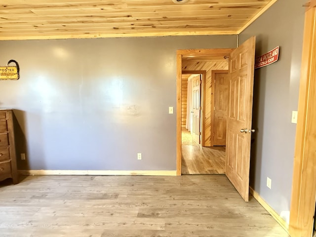 unfurnished bedroom featuring crown molding, light hardwood / wood-style floors, and wooden ceiling