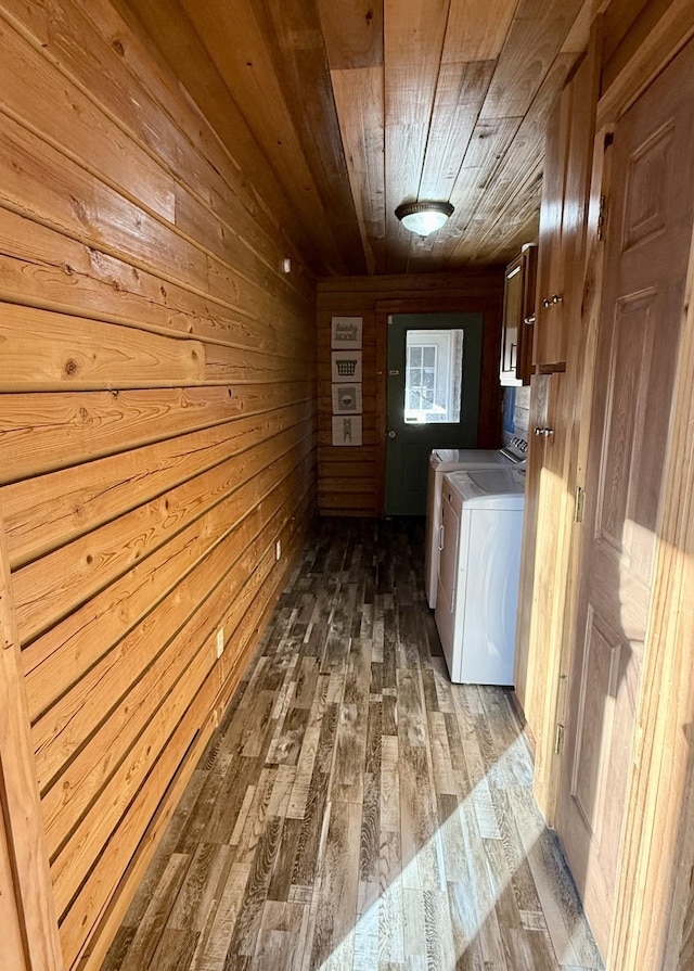 clothes washing area featuring washer and clothes dryer, wood walls, and wood ceiling