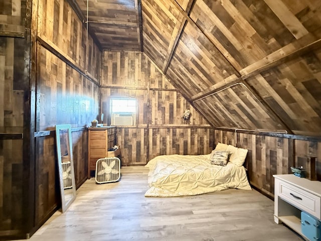 unfurnished bedroom featuring cooling unit, light wood-type flooring, and vaulted ceiling