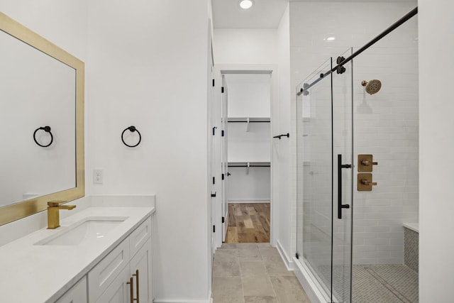 bathroom featuring walk in shower and vanity