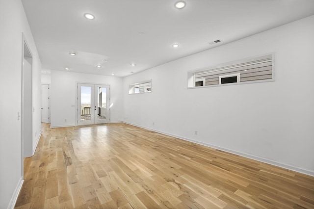 empty room with light hardwood / wood-style floors and french doors