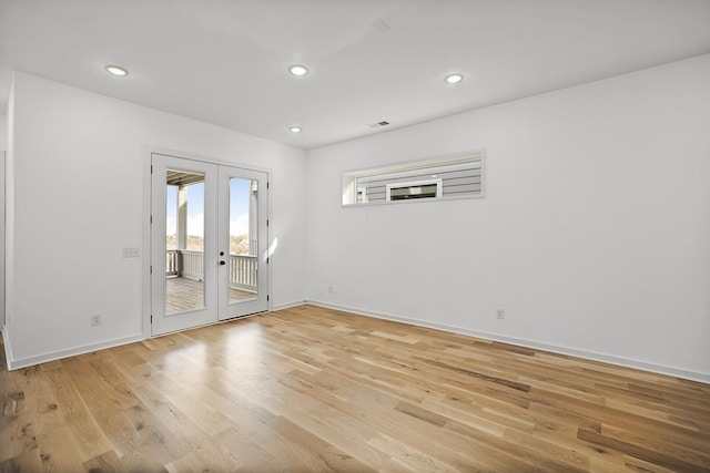 empty room with light hardwood / wood-style flooring and french doors