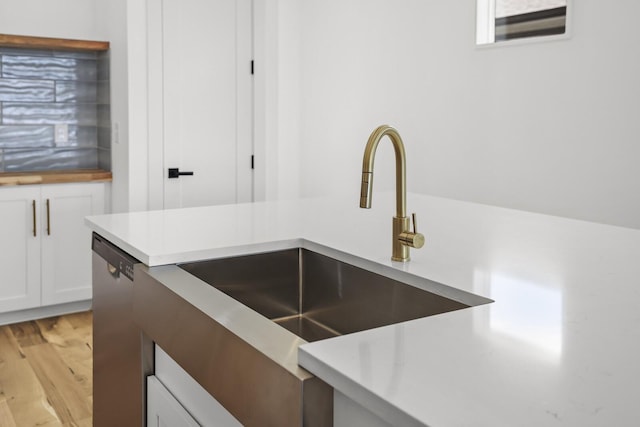 kitchen with sink, white cabinetry, dishwasher, and light wood-type flooring