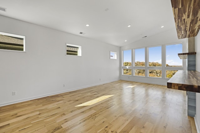 unfurnished living room featuring lofted ceiling and light hardwood / wood-style flooring