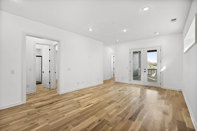 unfurnished room with french doors and light wood-type flooring