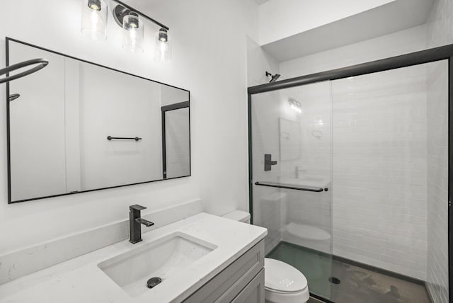 bathroom featuring toilet, vanity, and an enclosed shower