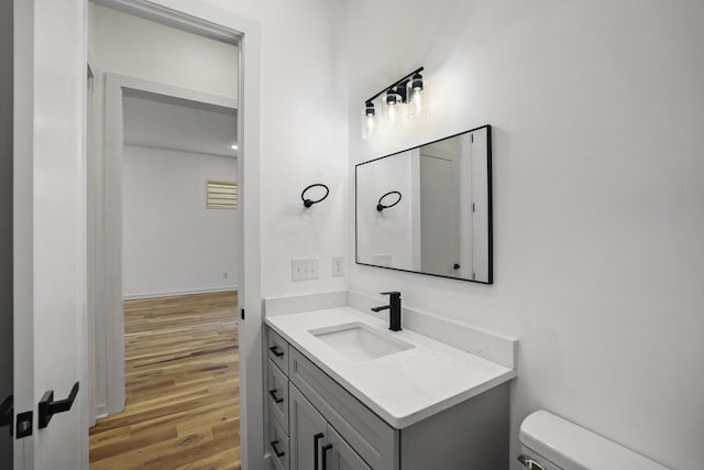 bathroom featuring hardwood / wood-style flooring, toilet, and vanity