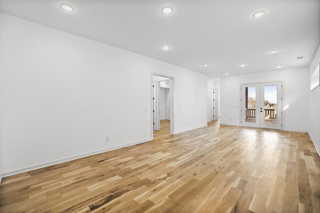 unfurnished living room with french doors and light hardwood / wood-style flooring