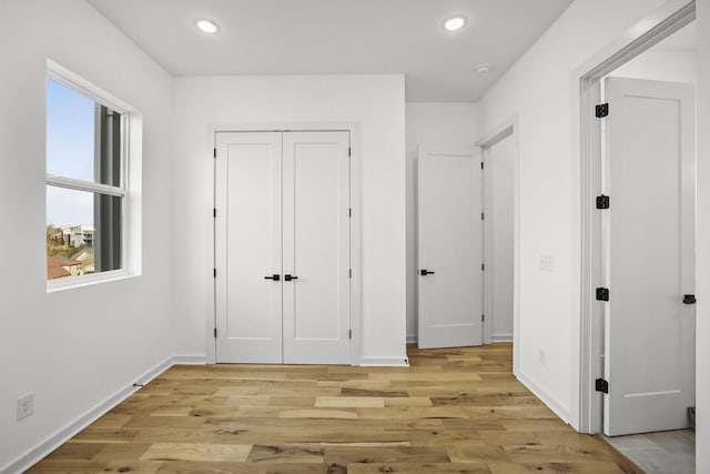 hallway with light hardwood / wood-style floors