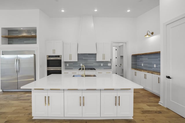 kitchen featuring decorative backsplash, white cabinetry, and stainless steel appliances