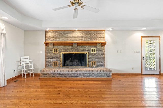 unfurnished living room featuring ceiling fan, a fireplace, and hardwood / wood-style flooring