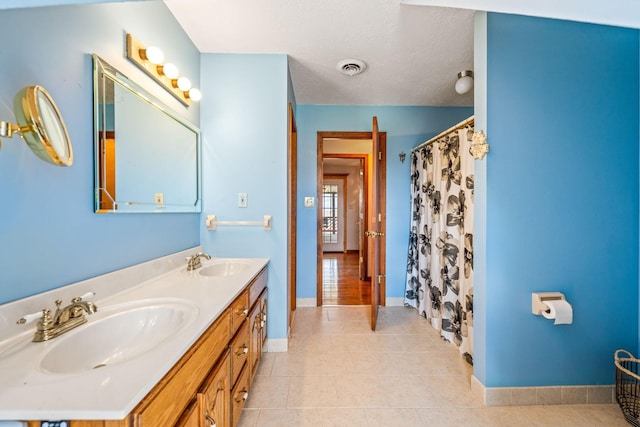 bathroom featuring a textured ceiling, vanity, and tile patterned flooring