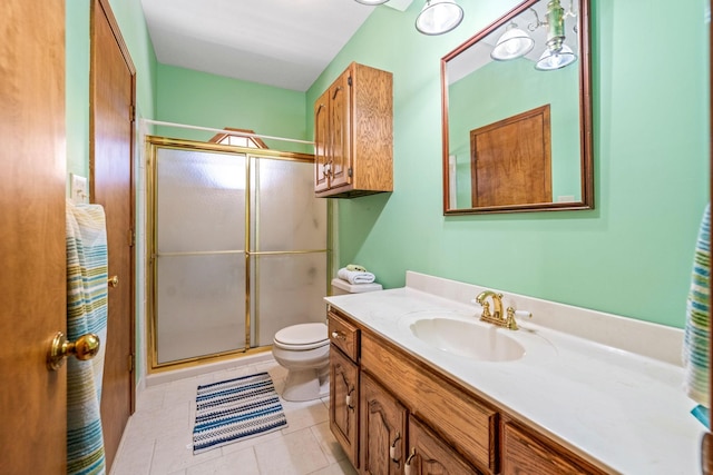 bathroom with a shower with shower door, tile patterned floors, vanity, and toilet