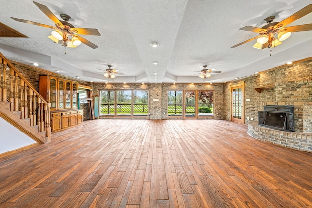 unfurnished living room featuring a textured ceiling, a healthy amount of sunlight, and wood-type flooring