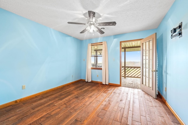 unfurnished room with ceiling fan, wood-type flooring, a textured ceiling, and french doors