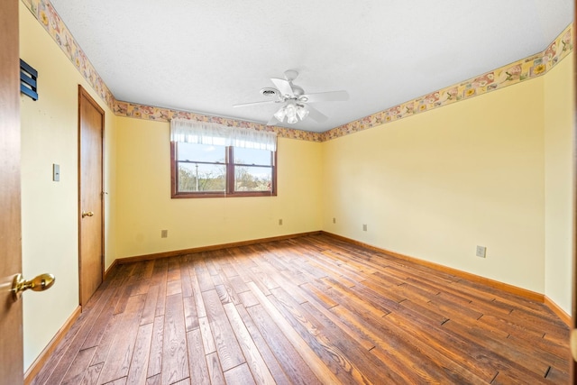 empty room with ceiling fan and hardwood / wood-style floors