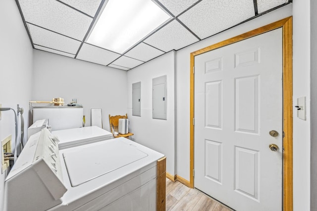 laundry area featuring washing machine and dryer, light hardwood / wood-style floors, and electric panel