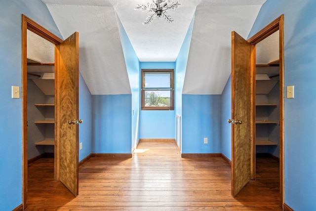 bonus room featuring light hardwood / wood-style floors, a textured ceiling, and lofted ceiling