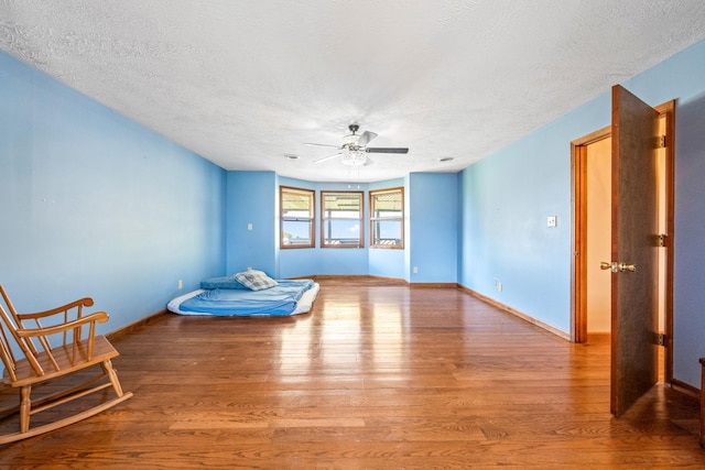 interior space featuring light hardwood / wood-style floors, a textured ceiling, and ceiling fan