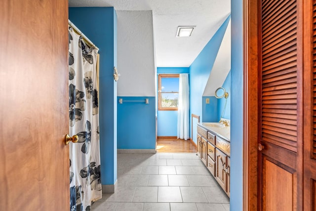 bathroom featuring a textured ceiling, tile patterned flooring, and vanity