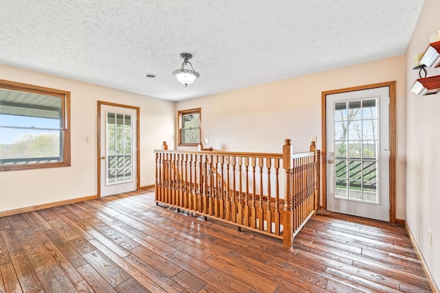 entrance foyer with hardwood / wood-style floors, a textured ceiling, and a healthy amount of sunlight