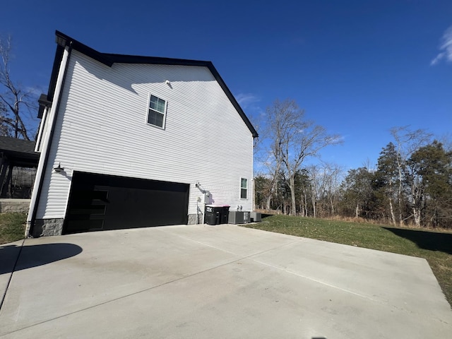 view of side of home with a garage and concrete driveway