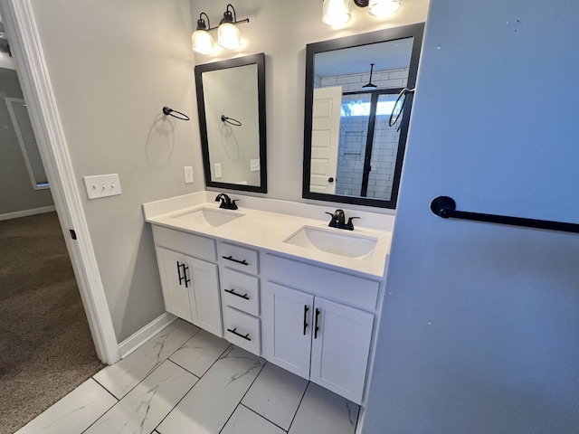 full bath featuring double vanity, marble finish floor, baseboards, and a sink