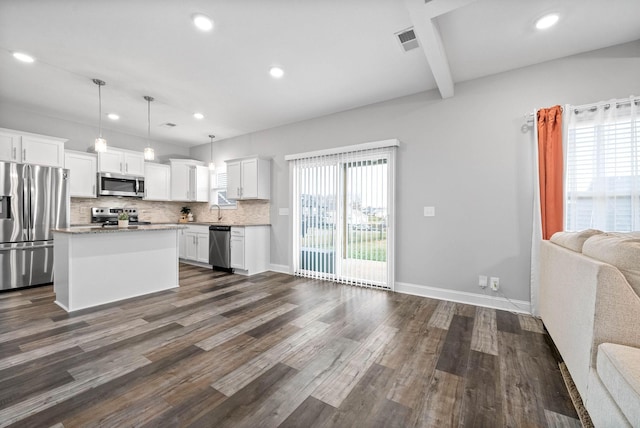 kitchen featuring white cabinets, appliances with stainless steel finishes, a center island, decorative light fixtures, and dark wood-type flooring