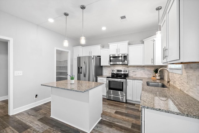 kitchen with white cabinetry, appliances with stainless steel finishes, dark hardwood / wood-style floors, a center island, and sink