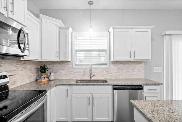 kitchen featuring pendant lighting, sink, white cabinets, and appliances with stainless steel finishes