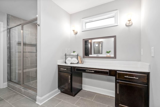 bathroom featuring tile patterned floors, a shower with shower door, and vanity