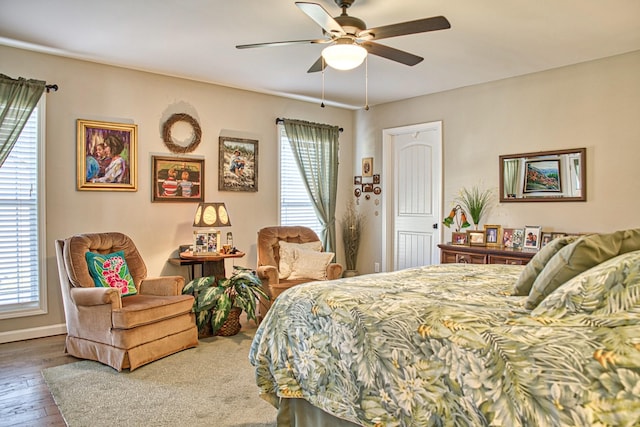 bedroom featuring ceiling fan, multiple windows, and hardwood / wood-style flooring