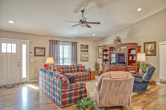 living room with ceiling fan, light wood-type flooring, and lofted ceiling