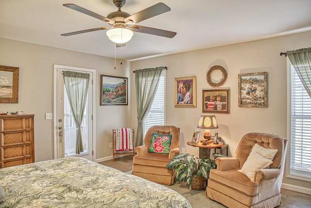 bedroom with ceiling fan, hardwood / wood-style flooring, access to outside, and multiple windows