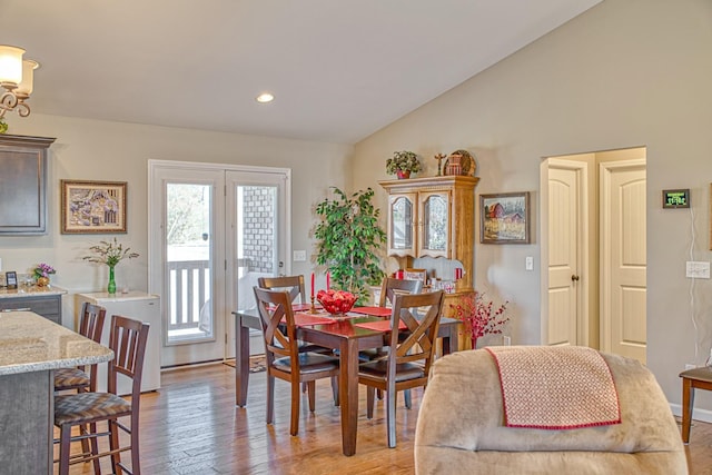 dining area with lofted ceiling and light hardwood / wood-style flooring