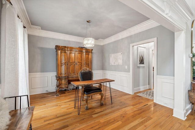 dining room with light hardwood / wood-style floors, ornamental molding, and a chandelier