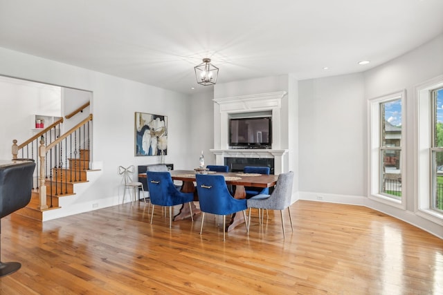 dining space with a notable chandelier and light hardwood / wood-style flooring