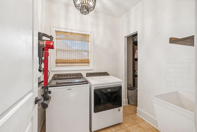 laundry area with a chandelier, light tile patterned floors, and washing machine and dryer