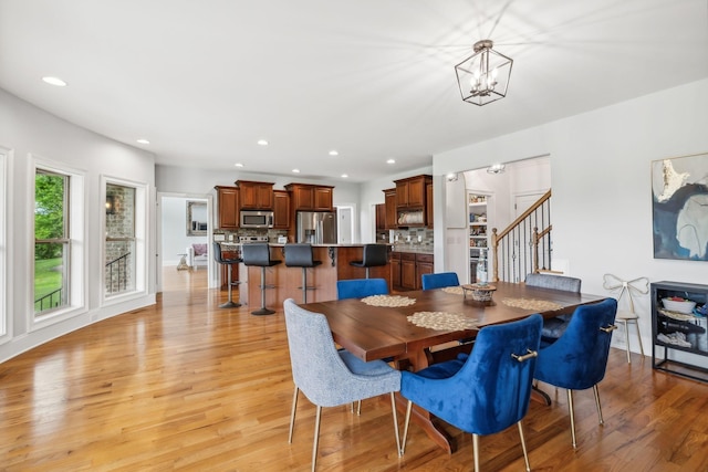 dining space featuring a notable chandelier and light wood-type flooring