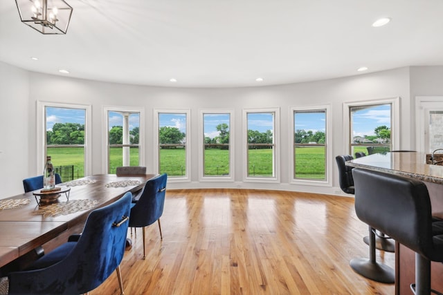 home office featuring light hardwood / wood-style floors and a chandelier