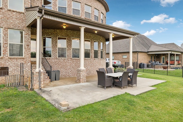 back of property with a yard and a patio