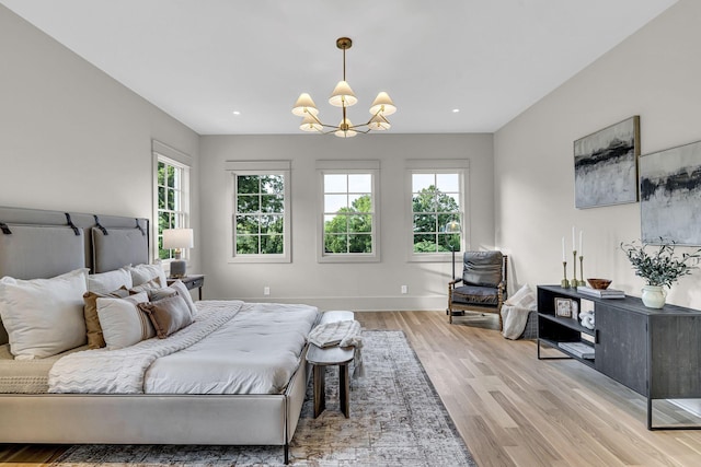 bedroom featuring light wood-type flooring and a notable chandelier