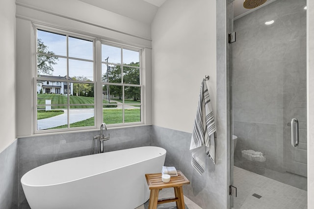 bathroom featuring independent shower and bath and tile walls