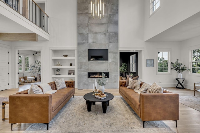 living room with a fireplace, built in features, and a wealth of natural light