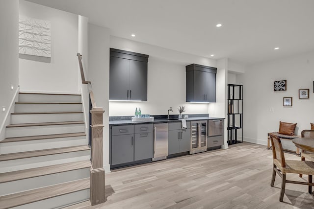 kitchen with wine cooler, dishwasher, gray cabinets, and light hardwood / wood-style floors