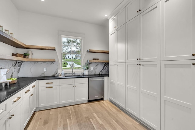 kitchen featuring dishwasher, light hardwood / wood-style floors, decorative backsplash, sink, and white cabinetry