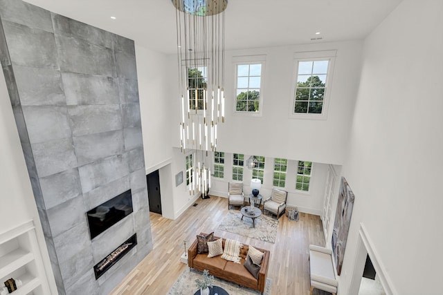 living room with a tiled fireplace and light hardwood / wood-style floors